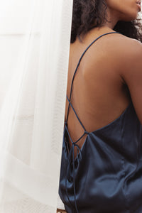 Our model wearing Dee Navy silk camisole set on white background - side look